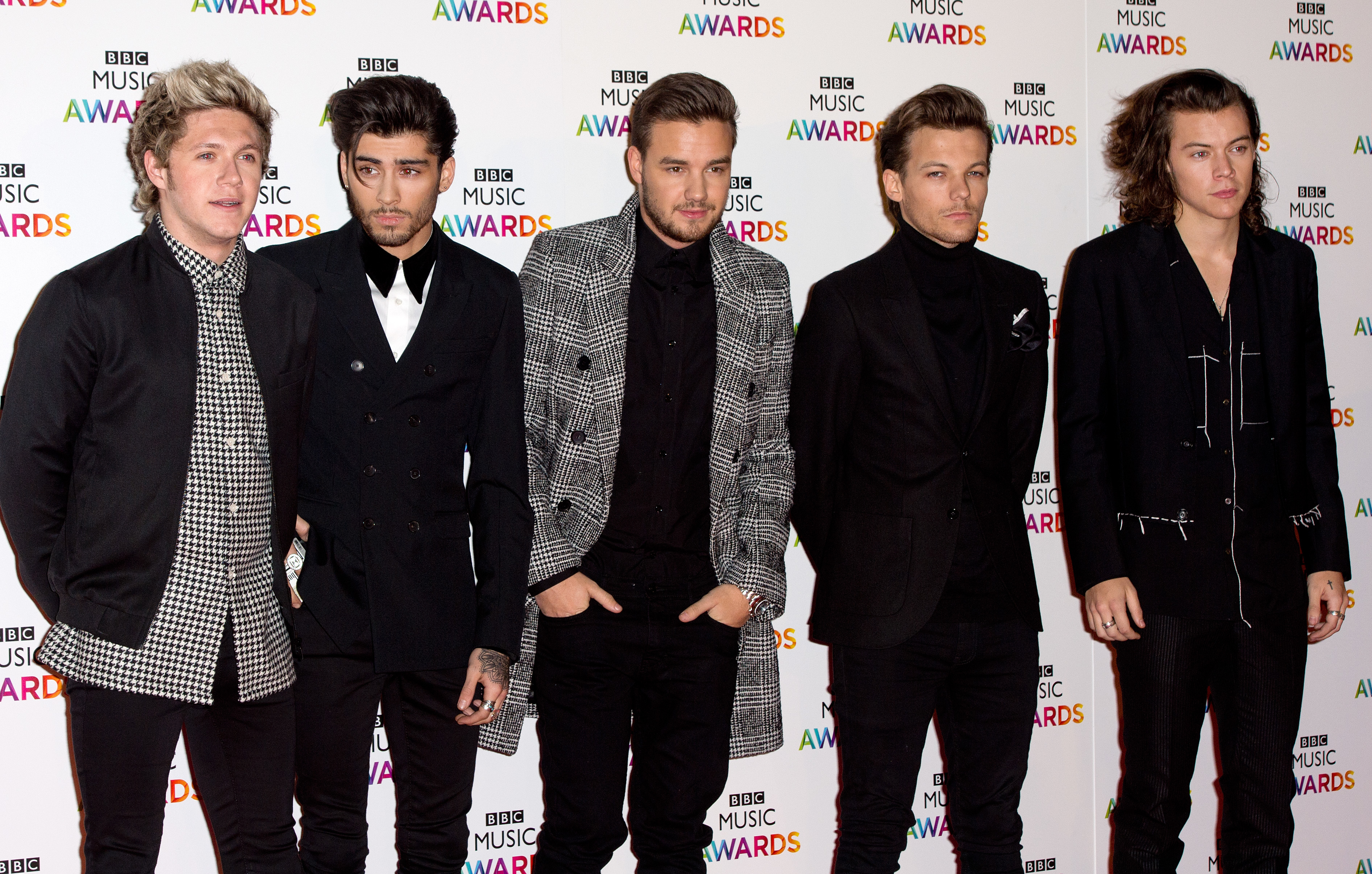 One Direction on a red carpet at the BBC Music Awards, wearing various black and white outfits