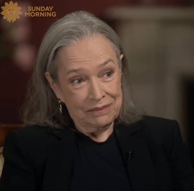 Kathy Bates with shoulder-length hair sits for an interview on &quot;Sunday Morning,&quot; wearing a dark top and blazer